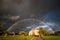 Stormy cloudy rainbow sky in countryside