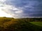 Stormy couds and sunset sky over fields