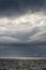 Stormy gray skies above the Southern Ocean with a sunbeam hitting the water, as a nature background