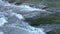 A stormy mountain river carries water along the rocks