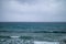 stormy sea on the Mediterranean coast, rain on the sea with high waves, abnormal storm and waves with shiuma, cloudy sky and cold