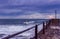 Stormy sea pier with motor boat coming in from a fishing expedition