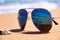 Stormy sea and shell are reflected in the mirror sunglasses on tropical beach ocean on background