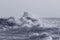 Stormy sea wave covering cliff