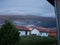 Stormy severe weather with arcus shaft and cumulonimbus clouds, cloudburst or shower and sunshine behind rain above settlement