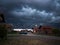 Stormy severe weather during storm with dark scary clouds, above settlement during summer evening