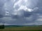 Stormy sky with dark clouds. Storm and rain over the village. Summer landscape with a thunderstorm front in the countryside