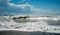 Stormy Sky and wavy ocean with waves hitting the seashore full pebbles