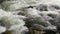 Stormy stream of water between rocks.