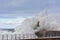 Stormy wave over old lighthouse and pier of Viavelez.