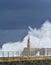 Stormy wave over old lighthouse and pier of Viavelez.