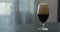 Stout beer drops slide from tulip glass on terrazzo countertop with copy space