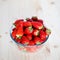 Straberries in a glass bowl on a wooden table