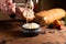 Stracciella cheese in a plate. The hand puts on the bread