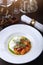 Straciatella with persimmon and tomatoes. Food on a white plate. Restaurant menu concept.Festive table setting.Vertical