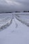 straight dirt road under snow
