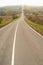 Straight empty misty road going up in autumn in the country