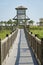 Straight footbridge path with wooden railings over the tall grasses at Destin, Florida