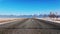 Straight line road fast trip winter travel. Background mountains blue sky 4K.