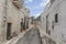 Straight narrow alley in the center of Alberobello Italian town