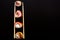 Straight parallel vertical lines of sushi and chopstick on black background