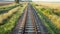 Straight railway tracks, train road through fields and forests.