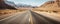 Straight road through the desert with bushes growing on both sides of the road