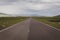 Straight tarmac road through green grasslands of Javakheti Plateau, Georgia.