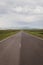 Straight tarmac road through green grasslands of Javakheti Plateau, Georgia.