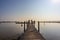 Straight wooden bridge between calm waters towards the recreation area in the Atoll at Woldstrand Zeewolde beach