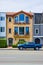 Straight on yellow San Francisco home 3 story with blue truck parked