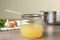 Straining delicious broth through sieve on wooden table