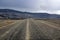 Straitght volcanic gravel road in Iceland.