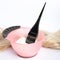 Strand of blond hair, bowl with dye and brush on background