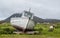 Stranded boat on a Scottish green field with sheep on the side