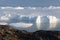 Stranded icebergs in the fog at the mouth of the Icefjord near Ilulissat. Nature and landscapes of Greenland.