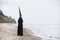 Strange figure in black cloak with the mirror face in seaside.