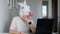 Strange funny video - woman with head of unicorn working on a computer. Self isolation while quarantine coronavirus