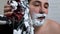 Strange, not the usual a man shaves beard blade from skates. A man uses skates when shaving his beard. Unusual facial