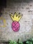 Strange pink and yellow spray painted graffiti logo on underpass