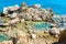 Strange Shape Rocks on the Seashore in Preveli Beach at Greek Island Crete, Greece. Swimmers Dive into the Blue Colored Waters