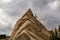 A strange spiky conical rock against a cloudy sky.