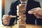 Strategic thinking and risk by business people pulls wooden blocks from the group