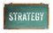 Strategy text word message written on a wide green old grungy vintage wooden chalkboard or retro blackboard with frame isolated