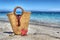 Straw bag, starfish and shell by the shore in hdr