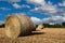 Straw bales on the field under blue sky with white clouds