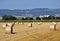 Straw bales in the field under Å ternberk, on the horizon of a wind turbine. Czech Republic.