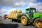 Straw bales tractor on countryside road UK