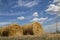 Straw bales under clouds