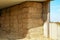 Straw in bales under a wooden canopy